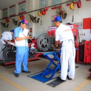 Mecânicos uniformizados trabalham em motocicletas dentro de um centro de serviços da Honda.