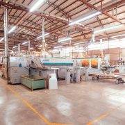 Vista ampla de uma fábrica organizada, com máquinas industriais e áreas de produção.